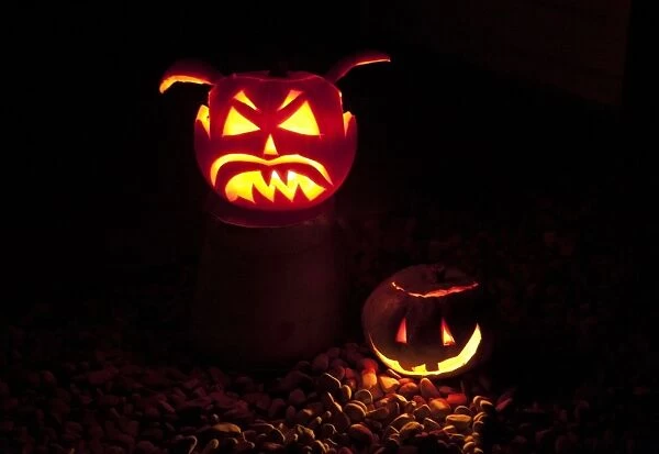 Pumpkin (Cucurbita sp. ) Jack O Lantern, two lit at night, Halloween custom, Clitheroe, Lancashire, England, november