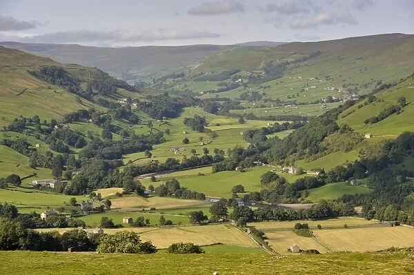 View across river valley with farmland, looking up Swaledale towards Gunnerside from Whitaside Moor