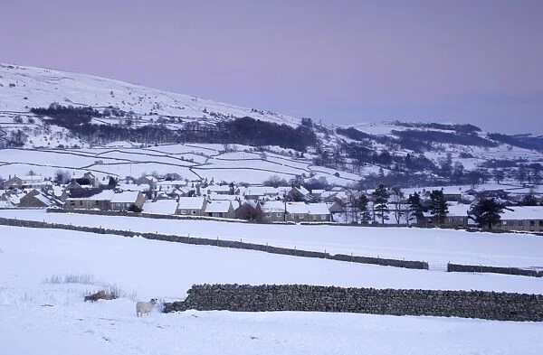 View of village and fells in heavy snowfall at dusk, Reeth, Swaledale, Yorkshire Dales N. P