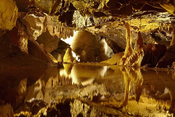 Stalactites and stalagmites reflected in pool, Goughs Cave, Cheddar Caves, Somerset