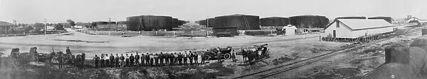 CALIFORNIA: OIL TANKS, c1910. Group of men standing in front of Standard Oil storage