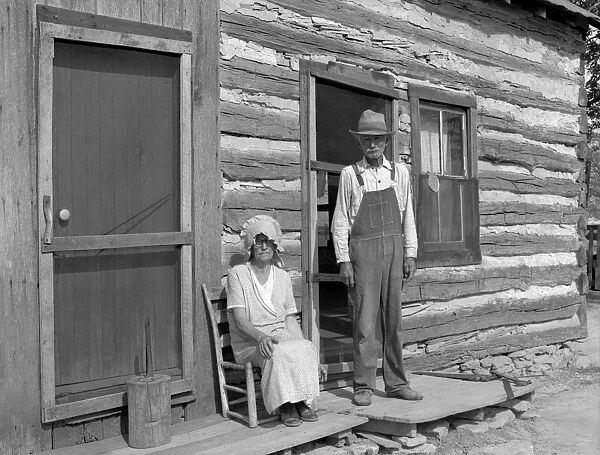 FARM COUPLE, 1936. An eighty-one year old farmer with his wife in front of their farmhouse