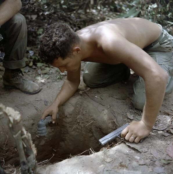 VIETNAM WAR, 1967. Sergeant Ronald Payne checking a tunnel for Viet Cong in the Ho Bo Woods
