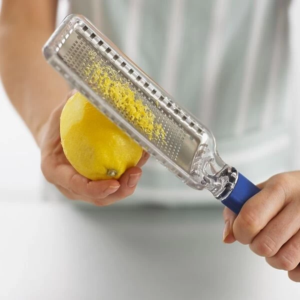 Boy using lemon grater to remove zest