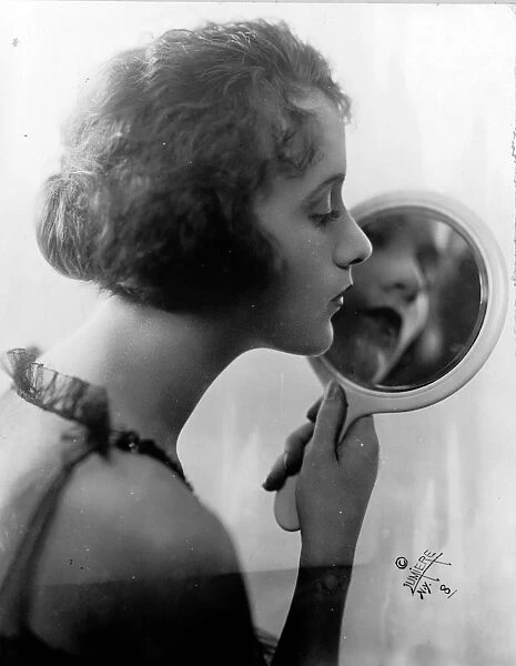 Constance Talmadge, American Silent Movie actress, looking into mirror 1921