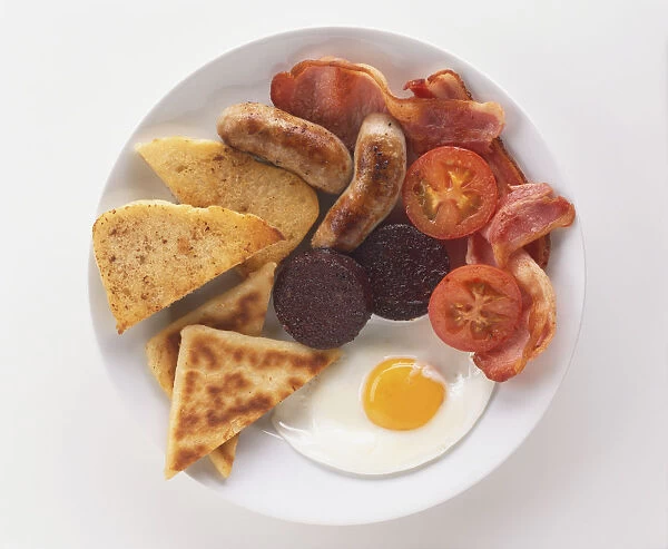 Ulster Fry, breakfast plate including sausages, bacon, black pudding, fried egg, tomatoes and bread, view from above