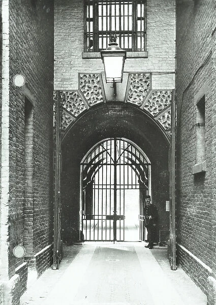 Millbank Prison: main passageway, Warden Barnard in doorway, 1885 (b  /  w photo)
