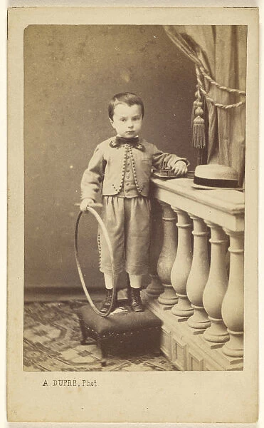 little boy standing ottoman holding hoop A Dupre