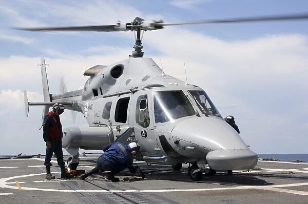 U. S. Sailors chock and chain an Ecuadorian Navy Bell 230 helicopter