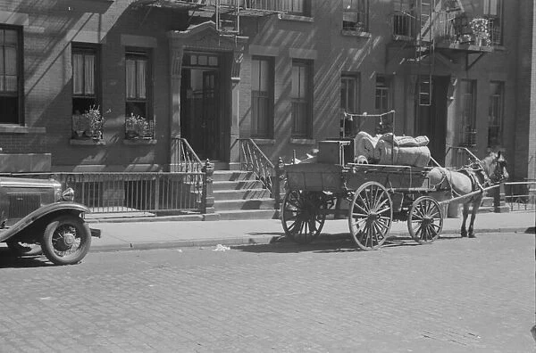 A tenant is moving on horse-drawn wagon, 61st Street between 1st and 3rd Avenues, New York, 1938. Creator: Walker Evans