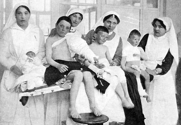 Wounded children from Ypres with nurses at La Panne, Belgium, First World War, 1914-1918, (c1920)