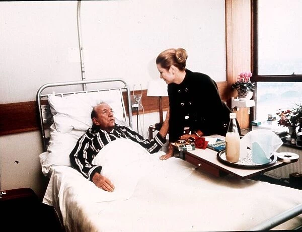 Noel Coward lying in hospital bed visited by Princess Grace of Monaco in St Thomas
