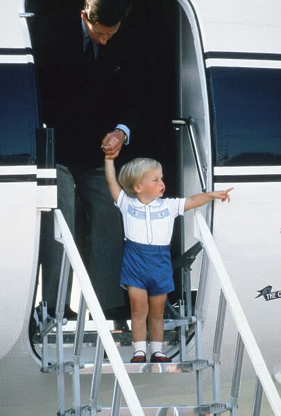 Prince Charles helping a young Prince William down the steps of the aircraft after