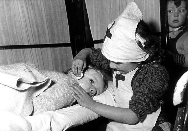 Three year old Brenda Aukett being checked over by nurse Janice Garry, aged 5