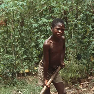 Barefoot boy with mattock, Sierra Leone