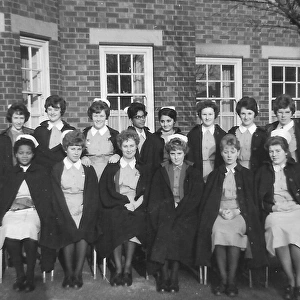 Black nurses amongst white nurses having a group picture