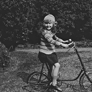 Girl on a bicycle in a garden