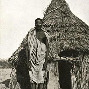 Sudan - A Shilluk man outside his house