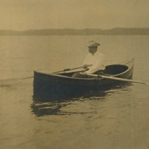 Theodore Roosevelt, seated in rowboat, rowing
