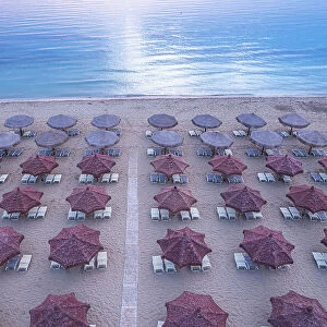 Aerial view of large group of tidy beach umbrellas facing the Mediterranean Sea, Italy, Europe