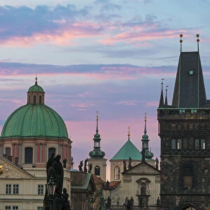Details of statues and spires at Charles Bridge at sunrise, featuring dome of Church of Saint Francis of Assisi and Old Town Bridge Tower, UNESCO World Heritage Site Prague, Bohemia, Czech Republic (Czechia), Europe