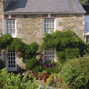Stone cottage with summer flowers in the garden at St. Agnes, Cornwall
