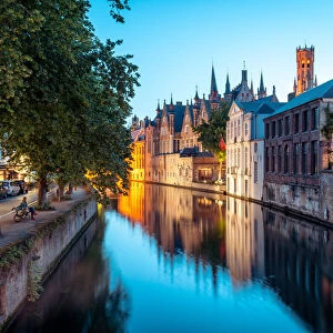 A tranquil canal scene in Bruges, with the spires of the Stadhuis (Town Hall) in the