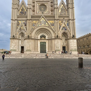 View of the facade of the Gothic cathedral with golden mosaics and bronze doors, Orvieto
