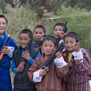Young Bhutanese boys playing with their toy guns, Paro, Bhutan, Asia