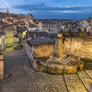 Typical paved alley in the old Sassi quarter at dusk. Matera, Basilicata region, Italy