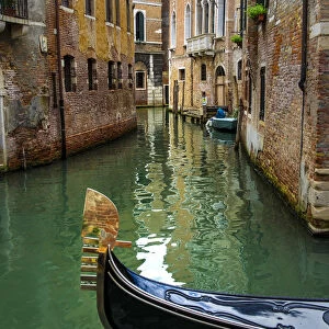 Venice, Veneto, Italy. Gondola sailing through a street canal