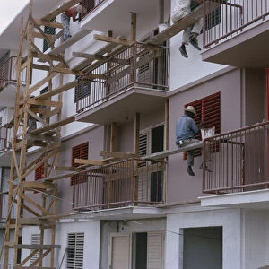CUBA Construction workers and painters on wooden scaffolding working on muli-storey