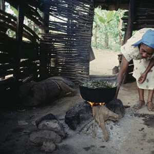 DOMINICAN REPUBLIC, Montesita Woman cooking over open fire