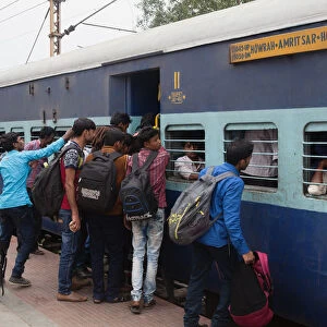 India, West Bengal, Asansol, Passengers attempt to board an overcrowded second-class carriage of a train at Railway Station