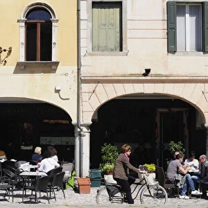 Italy, Friuli Venezia Giulia, Udine, Piazza Mateotti with cafes & cyclist