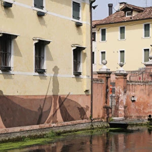 Italy, Veneto, Treviso, canal & building with fishing wall painting