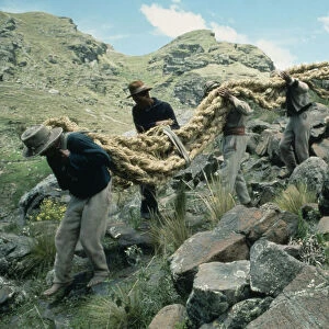 PERU Apurimac Gorge Men from the Chumbivilcas hills carrying length of thick rope made