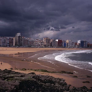SPAIN, Asturias, Gijon High rise city buildings overlooking beach with people in water