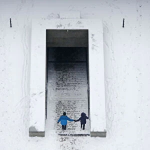 A couple descend into an underpass tunnel after heavy snowfall in Berlin