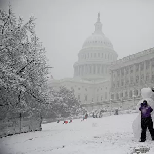 People build a snowman outside the U. S. Capitol in Washington