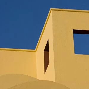 Mexico, San Miguel de Allende. Angled roofline of yellow building against blue sky