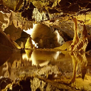 Stalactites and stalagmites reflected in pool, Goughs Cave, Cheddar Caves, Somerset