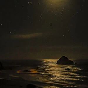 USA, Oregon, Bandon Beach. Lunar eclipse reflects on ocean shore at night