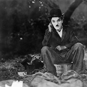 CHAPLIN: THE CIRCUS, 1928. Charlie Chaplin seated on a crate in the film The Circus