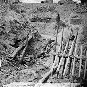 CIVIL WAR: TRENCH, 1865. Dead Confederate soldier in a trench beyond a section