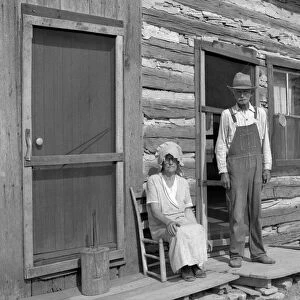 FARM COUPLE, 1936. An eighty-one year old farmer with his wife in front of their farmhouse