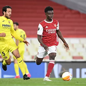 Arsenal's Bukayo Saka Outmaneuvers Villarreal's Daniel Parajo in UEFA Europa League Semi-Final Showdown at Empty Emirates Stadium