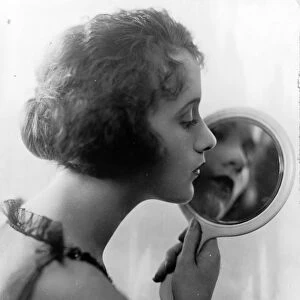 Constance Talmadge, American Silent Movie actress, looking into mirror 1921
