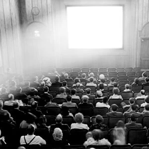 Couples in a theater preparing to watch a film