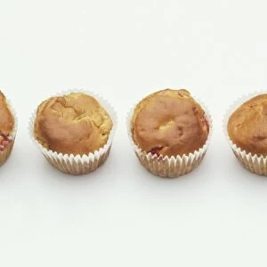 Six muffins in paper cases, arranged in a row